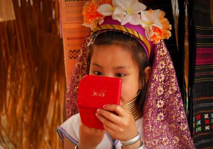 Putting on make-up, child at Mae Ai